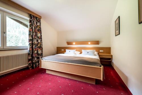 a bedroom with a bed and a large window at Das Filzmoos in Filzmoos