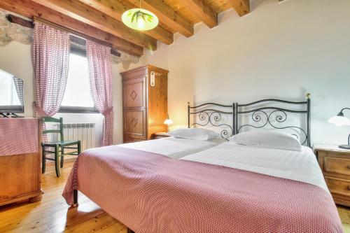 a bedroom with a large bed with a red and white blanket at Casa Romantica La Parenzana in Buje