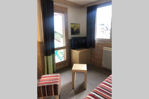 Cette chambre comprend un lit, une table et une télévision. dans l'établissement Les Cristaux de La Plagne - BELLE PLAGNE 7 PERS, à Belle Plagne
