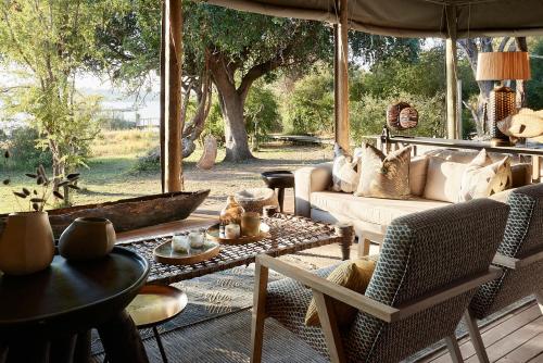 a living room with a couch and a table at Victoria Falls River Lodge in Victoria Falls