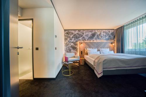 a hotel room with a bed and a window at FourSide Hotel Salzburg Messe, Trademark Collection by Wyndham in Salzburg