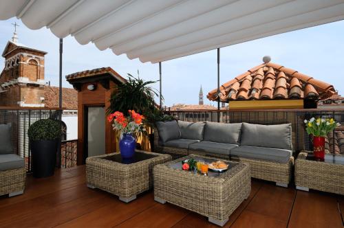 a patio with a couch and chairs on a roof at UNAHOTELS Ala Venezia-Adults 16 in Venice