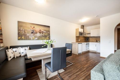 a living room with a dining room table and a kitchen at Das Filzmoos in Filzmoos