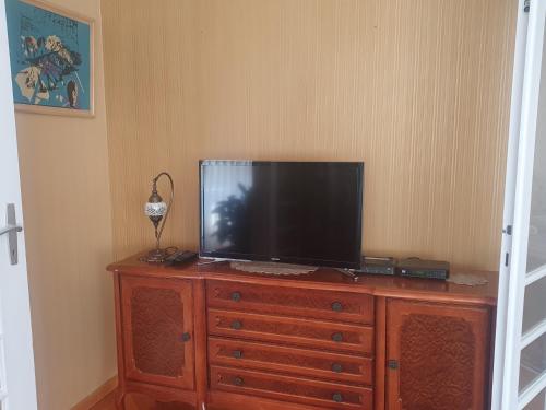 a television on top of a wooden dresser at Vijecnica Tuzlaks apartments in Sarajevo