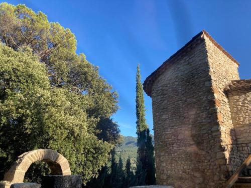 a stone building with an archway next to trees at Domaine La Tour - SPA - Jacuzzi - Sauna - Massage - 4 SAISONS - Piscine Chauffée Toute l'année - Heated POOL - 800m City Centre Nyons in Nyons