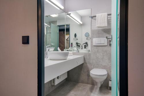 a bathroom with a sink and a toilet at FourSide Hotel Salzburg Messe, Trademark Collection by Wyndham in Salzburg