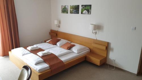 a bedroom with a wooden bed with towels on it at Penzión Dubo in Liptovský Mikuláš
