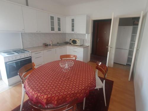 a kitchen with a table with a red tablecloth on it at Vijecnica Tuzlaks apartments in Sarajevo