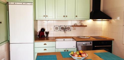 a kitchen with a bowl of fruit on a table at The Veranda of Gavrion-Exclusive, Centrally located with Seaview in Gavrion