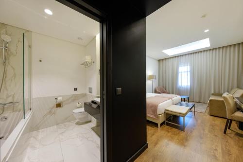 a hotel room with a bed and a bathroom at SDivine Fatima Hotel, Congress & Spirituality in Fátima