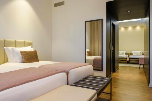 a hotel room with two beds and a mirror at SDivine Fatima Hotel, Congress & Spirituality in Fátima