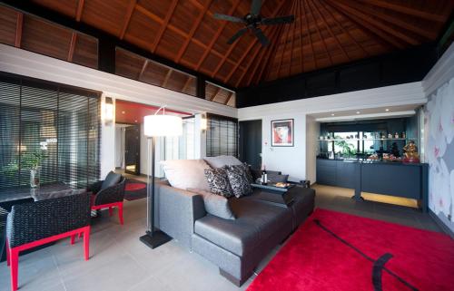a living room with a couch and a red rug at The Pavilions Phuket in Bang Tao Beach