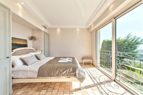 une chambre avec un lit et une grande fenêtre dans l'établissement Villa Pertuades Villa with amazing sea view and swimming pool, à Vallauris