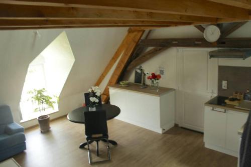 Cette chambre mansardée dispose d'une table et d'une cuisine. dans l'établissement Studio neuf proche d'Alençon et Le mans, à Lonrai