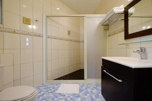 uma casa de banho com um chuveiro, um WC e um lavatório. em Haiye Guest House em Kenting