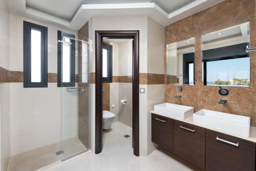 a bathroom with two sinks and a shower and a toilet at Ixia Breeze 3 in Ixia