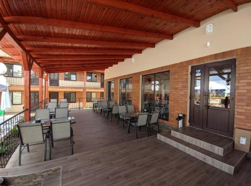 a large deck with tables and chairs on a building at Гостинний дім Александрія in Berehove