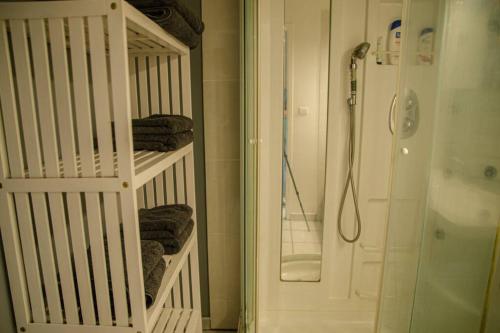 Un baño con ducha y una cuna blanca. en Le Géranium: T3 avec vue mer exceptionnelle, en Saint-Denis