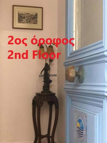 a sign on a door with a statue on a table at ERRIKA in Ermoupoli