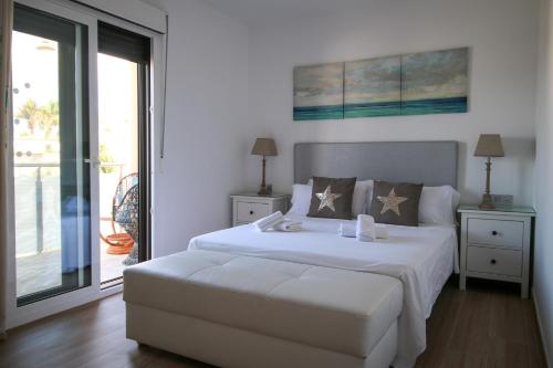 a bedroom with a large white bed and a balcony at Villa Golf y Mar in San Miguel de Abona