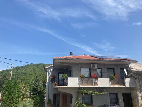 una casa con un balcón con flores. en Guest house Sara, en Rijeka
