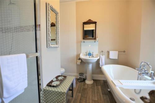 y baño con bañera, aseo y lavamanos. en Ascot House Hotel en Torquay