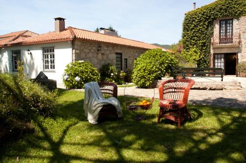a man sitting on a bench in front of a house at Casa do Ameal in Viana do Castelo