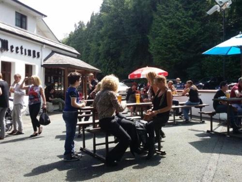 um grupo de pessoas sentadas em mesas em um pátio em The Meetings B&B em Avoca