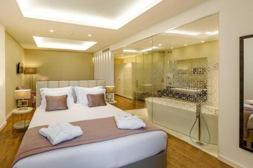 a bedroom with a large bed and a bathroom at SDivine Fatima Hotel, Congress & Spirituality in Fátima