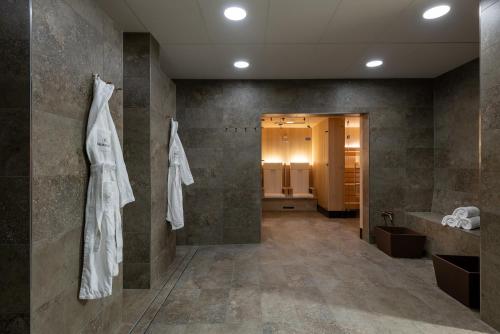 a bathroom with a robe hanging on a wall at Sunstar Hotel Lenzerheide in Lenzerheide