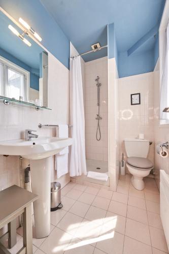 une salle de bain avec un lavabo, des toilettes et une douche dans l'établissement LOGIS Hôtel Du Théâtre, à Tours