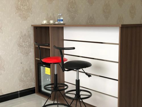 two bar stools in front of a wall at Phung Hung Boutique Hotel in Phu Quoc