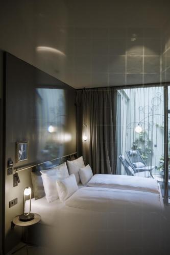 a bedroom with a large white bed with a window at Altstadthotel Weisses Kreuz in Innsbruck