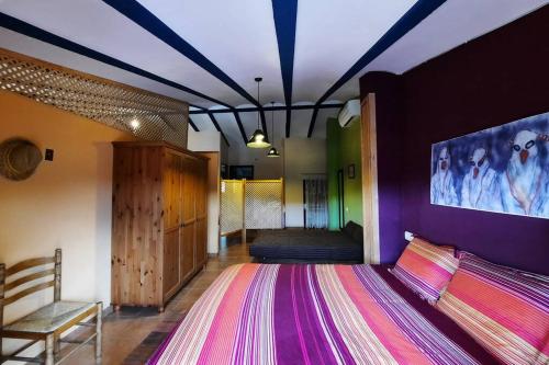 ein Schlafzimmer mit einem Bett mit einer lila Wand in der Unterkunft CA JOAN a VILLORES, Els Ports (País Valencià) in Villores