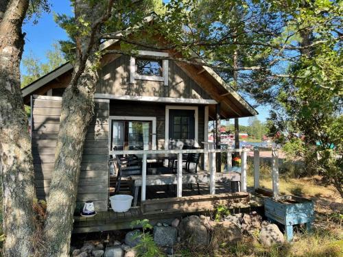 a tiny house with a porch and a tree at Kaunissaaren Maja in Kotka
