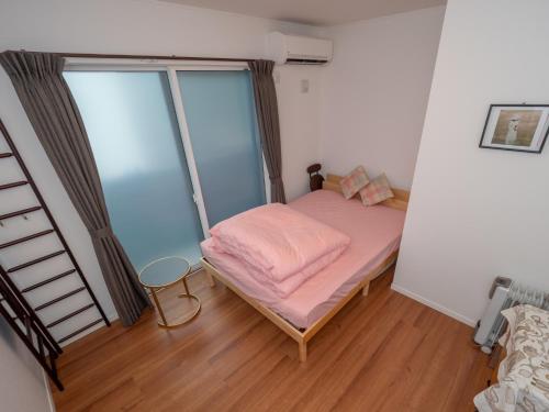 a small bed in a room with a window at Kamakura International House Double Room w Shower Toilette - Vacation STAY 11408 in Kamakura