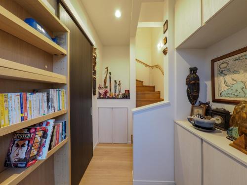 a hallway with wooden bookshelves and a staircase at Kamakura International House Double Room w Shower Toilette - Vacation STAY 11408 in Kamakura