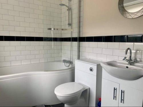 a bathroom with a sink and a toilet and a bath tub at The Glen Mona Hotel in Maughold