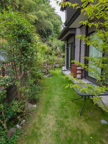 a yard with a bench next to a house at Kamakura International House Japanese-style room w Shower Toilette - Vacation STAY 11585 in Kamakura