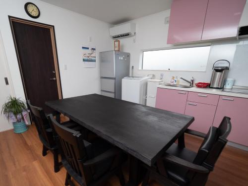 a kitchen with a black table and some pink cabinets at Kamakura International House Japanese-style room w Shower Toilette - Vacation STAY 11585 in Kamakura