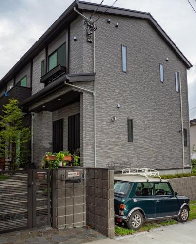 um carro verde estacionado em frente a uma casa em Kamakura International House Japanese-style room w Shower Toilette - Vacation STAY 11585 em Kamakura