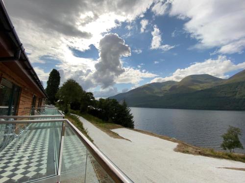 a balcony with a view of a lake and mountains at Black Sheep Hotels Cabins in Spean Bridge