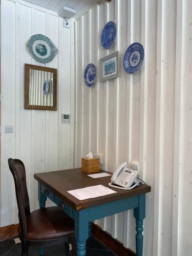 a table with a phone and plates on a wall at Black Sheep Hotels Cabins in Spean Bridge