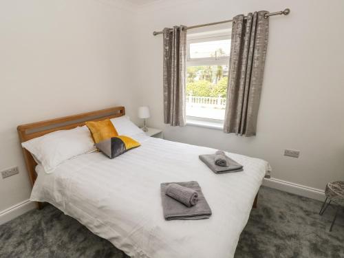 a bedroom with a bed with towels on it at Larkhill in Tenby