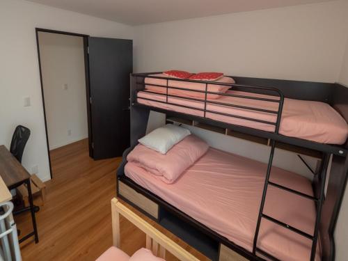 a room with two bunk beds with pink sheets at Kamakura International House Family room w Shower Toilette Min 1 female guest - Vacation STAY 11601 in Kamakura