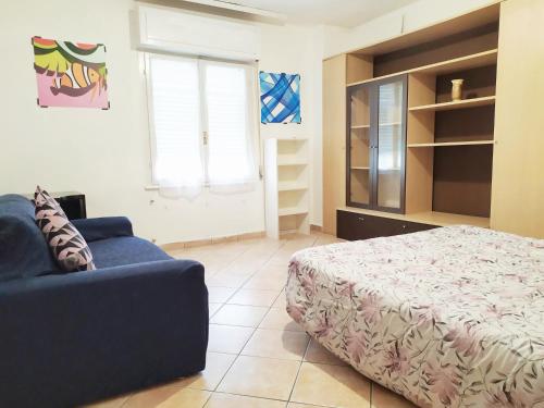 1 dormitorio con 1 cama y 1 sofá azul en Levico Centrale Apartment en Levico Terme