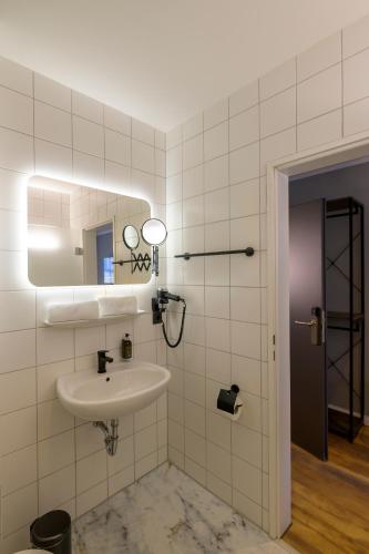 a bathroom with a sink and a mirror at Nikii City Hotel in Leverkusen