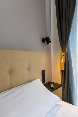 a bedroom with a white bed and a window at Nikii City Hotel in Leverkusen