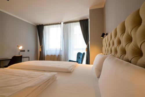 a hotel room with two beds and a window at Nikii City Hotel in Leverkusen