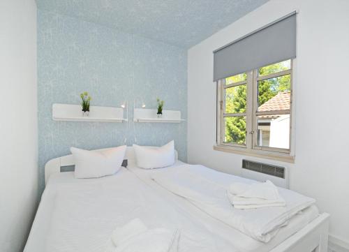 バンシンにあるFerienanlage Bansin Seepferdchen 5の白い枕と窓が備わる白いベッド